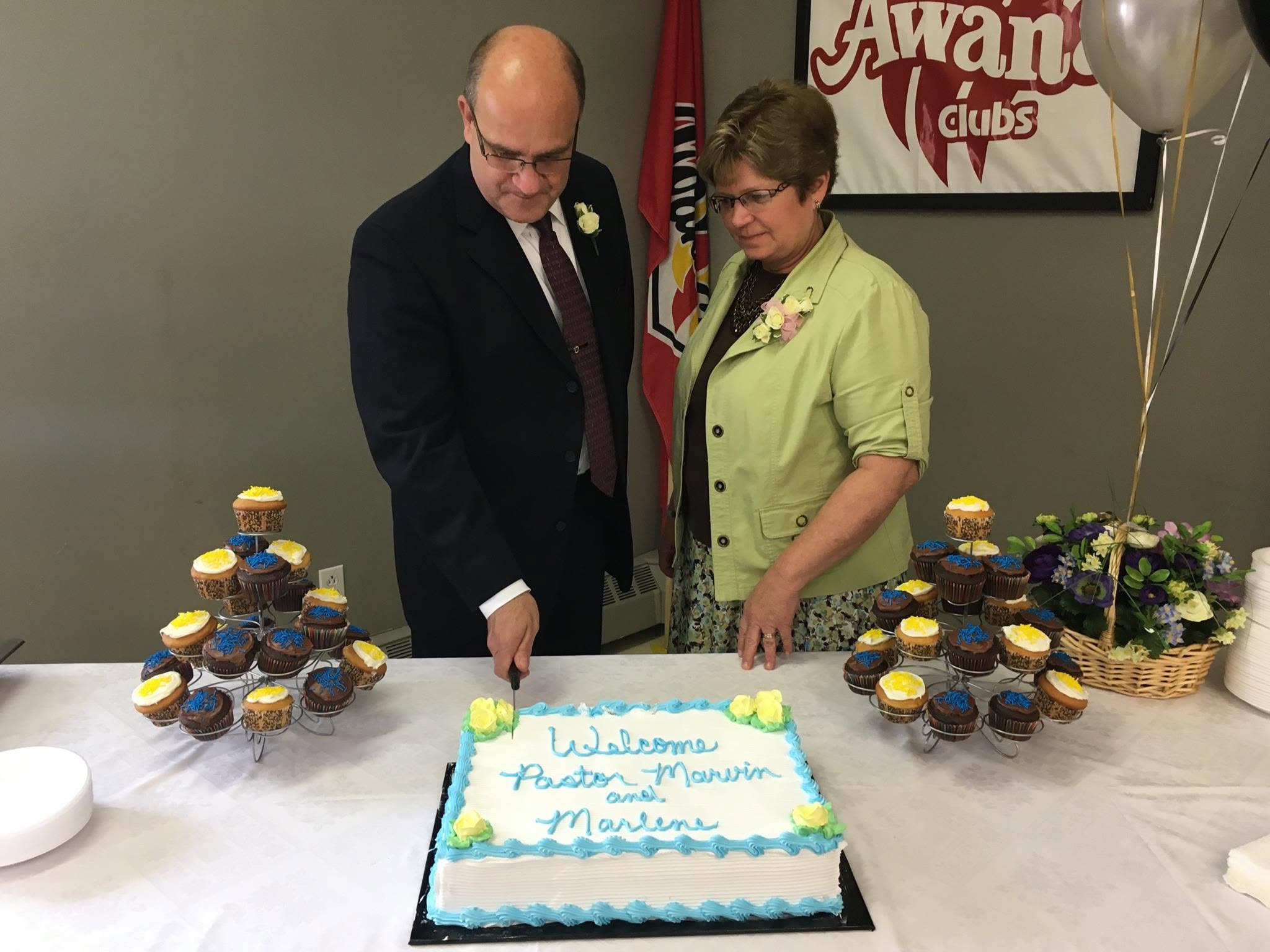 Cutting a cake welcoming Pastor Marvin and Marlene to Golden Harvest